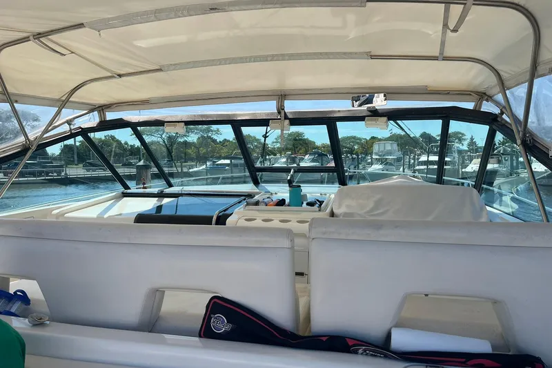 Slide: The Image of 1996 Tiara Yachts 3500 Express interior view at marina, showcasing helm and seating area. - 26