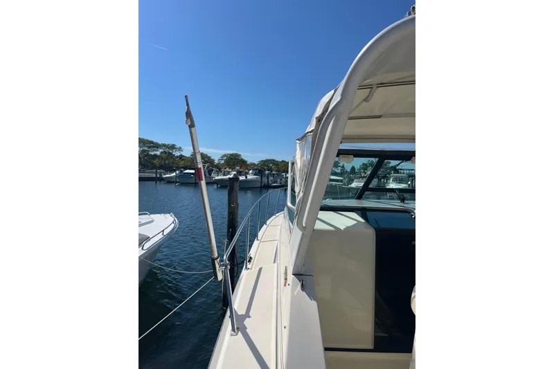 Slide: The Image of 1996 Tiara Yachts 3500 Express docked at a marina under clear blue skies. - 31
