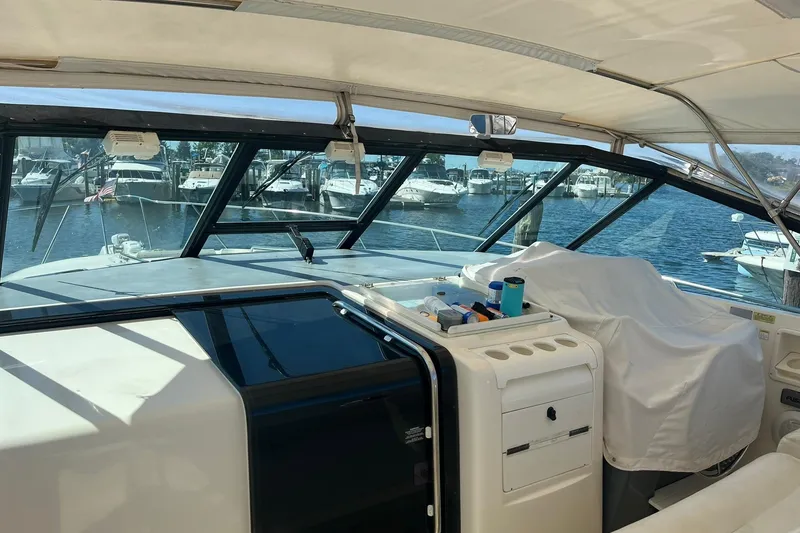 Slide: The Image of 1996 Tiara Yachts 3500 Express interior with marina view through large windows. - 32