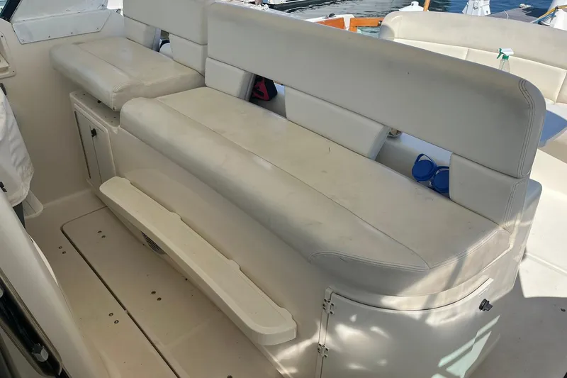 Slide: The Image of 1996 Tiara Yachts 3500 Express interior seating with white upholstery and storage compartments. - 33