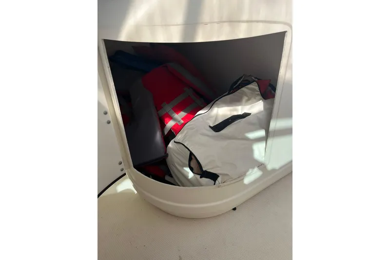 Slide: The Image of Storage compartment on a 1996 Tiara Yachts 3500 Express, containing life jackets and bags. - 34