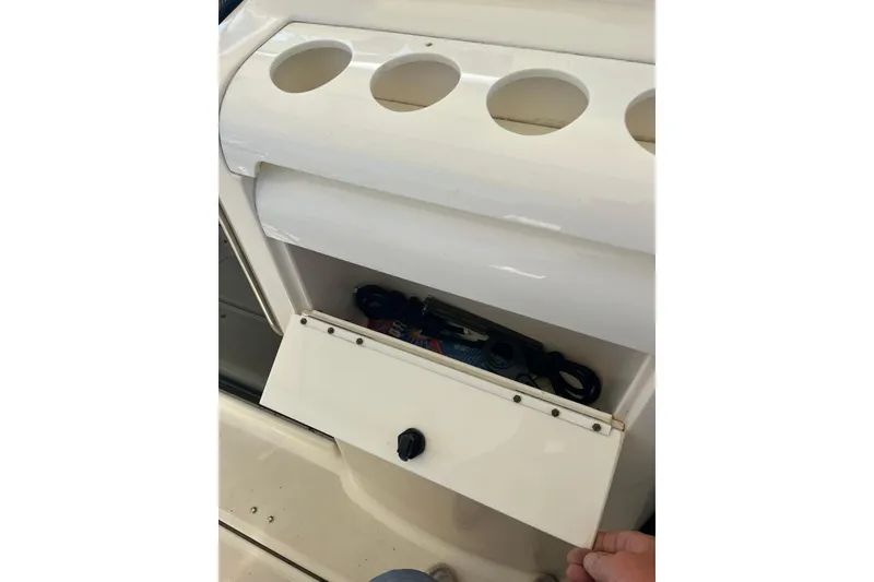 Slide: The Image of Storage compartment on a 1996 Tiara Yachts 3500 Express, featuring cup holders and open hatch. - 35