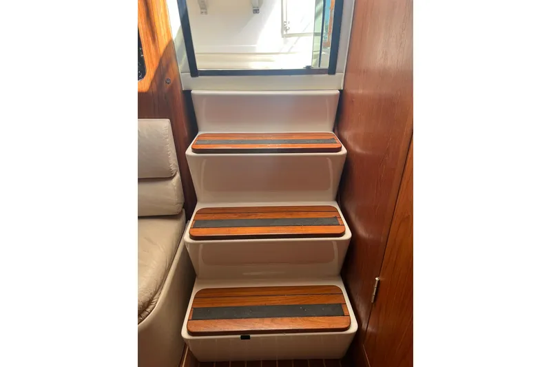 Slide: The Image of Staircase inside 1996 Tiara Yachts 3500 Express with wooden steps and white frame. - 50