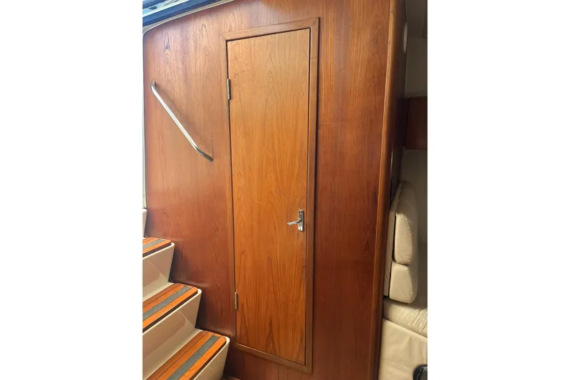 Slide: The Image of Interior of 1996 Tiara Yachts 3500 Express, featuring wooden door and staircase. - 52