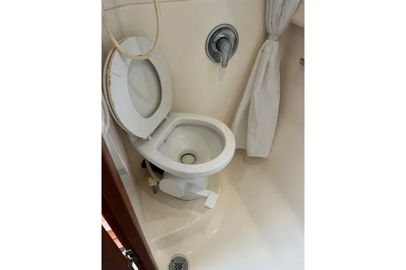 Slide: The Image of 1996 Tiara Yachts 3500 Express bathroom with toilet and shower controls. - 53