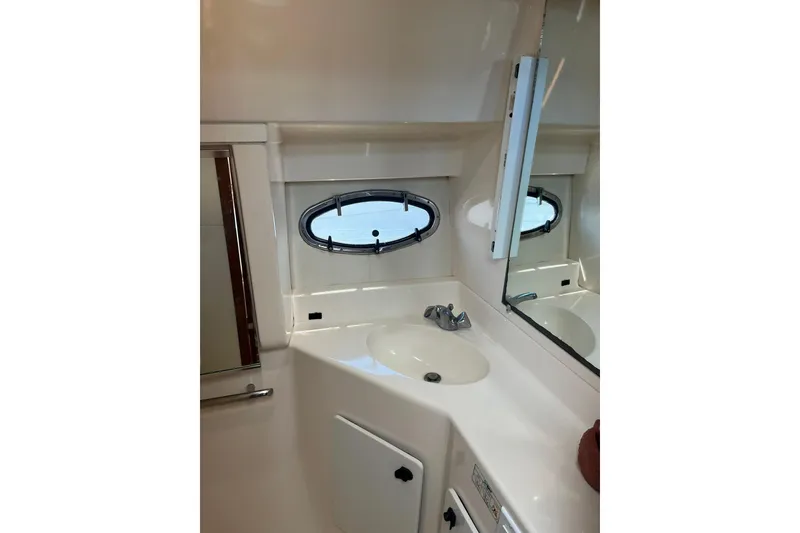 Slide: The Image of Bathroom interior of 1996 Tiara Yachts 3500 Express with sink and porthole window. - 54