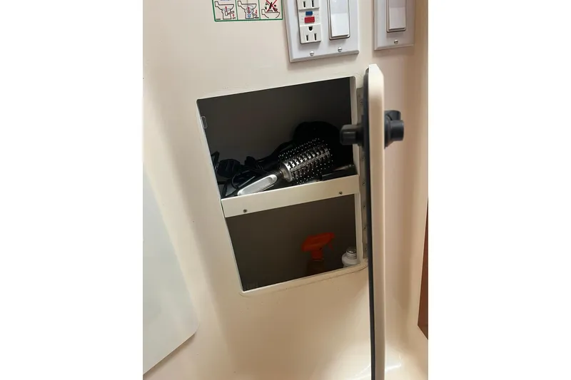 Slide: The Image of Storage compartment on a 1996 Tiara Yachts 3500 Express, containing grooming tools and spray bottle. - 59
