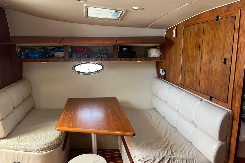 Slide: The Image of Interior of 1996 Tiara Yachts 3500 Express with cozy seating and wooden cabinetry. - 61