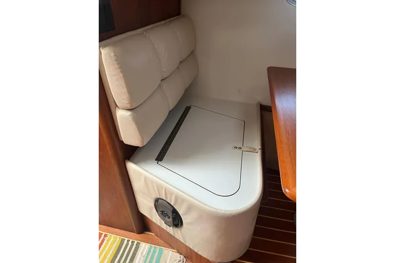 Slide: The Image of 1996 Tiara Yachts 3500 Express interior seating with storage compartment, featuring cushioned backrest. - 63