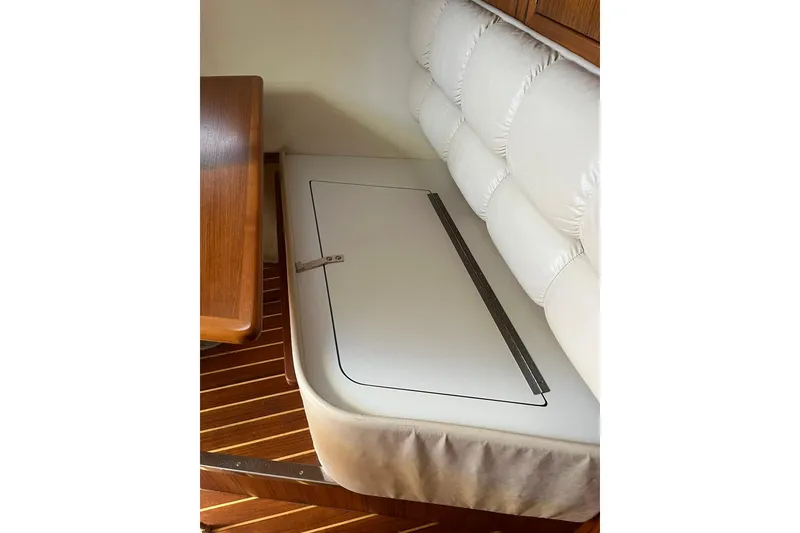 Slide: The Image of 1996 Tiara Yachts 3500 Express interior seating with storage compartment and wooden flooring. - 64