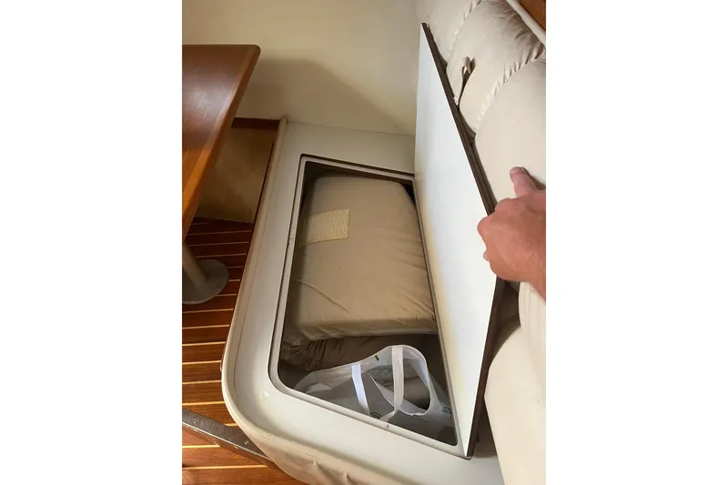 Slide: The Image of Storage compartment in 1996 Tiara Yachts 3500 Express, showcasing interior seating and wooden flooring. - 65