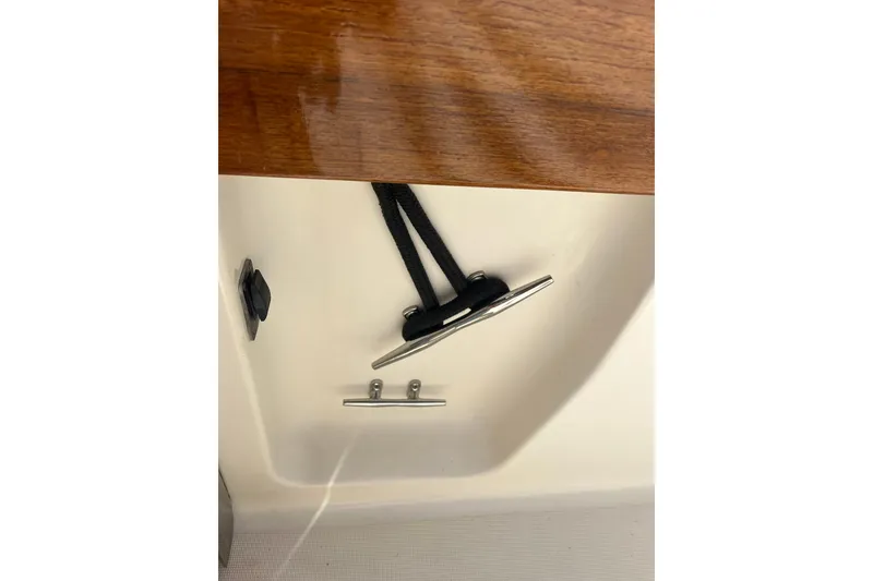 Slide: The Image of 1996 Tiara Yachts 3500 Express boat cleat with black rope on wooden deck. - 7