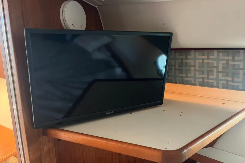 Slide: The Image of Vizio TV inside 1996 Tiara Yachts 3500 Express cabin, wooden and patterned interior. - 70