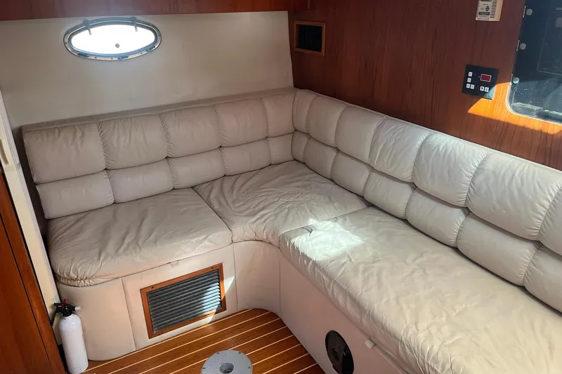Slide: The Image of Interior of 1996 Tiara Yachts 3500 Express with beige leather seating and wooden accents. - 85