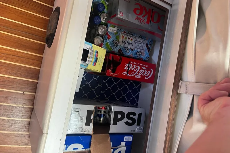 Slide: The Image of Storage compartment on a 1996 Tiara Yachts 3500 Express, stocked with various beverages. - 86