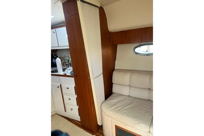 Slide: The Image of Interior of 1996 Tiara Yachts 3500 Express, featuring a cozy seating area and kitchenette. - 90