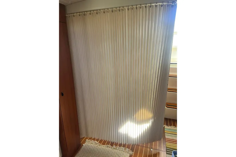 Slide: The Image of Curtained interior of a 1996 Tiara Yachts 3500 Express, showcasing elegant design and wood flooring. - 91