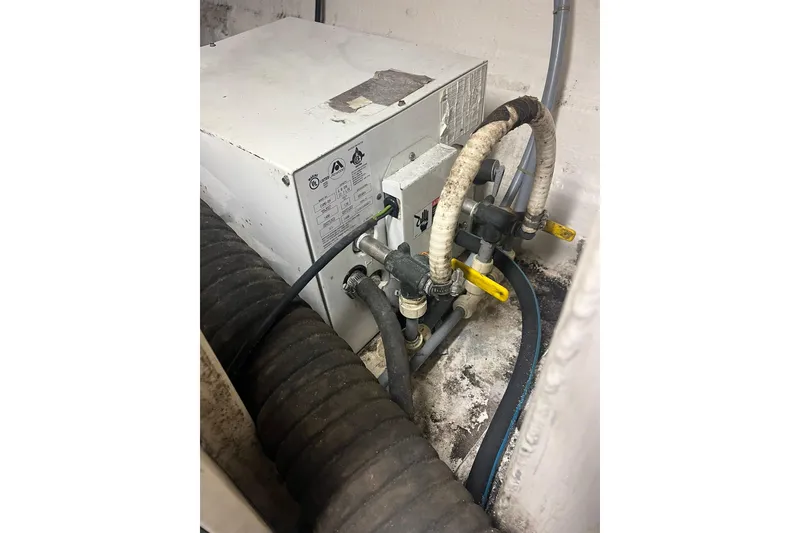 Slide: The Image of Engine compartment of a 1996 Tiara Yachts 3500 Express, featuring mechanical components and hoses. - 92