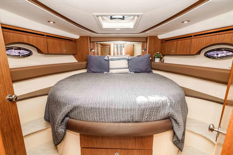Slide: The Image of Luxurious 2016 Meridian 441 Sedan yacht bedroom with elegant wood finishes and cozy bedding. - 15