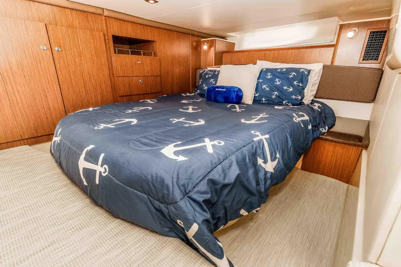 Slide: The Image of Luxurious 2016 Meridian 441 Sedan cabin with anchor-themed bedding and wooden cabinetry. - 18
