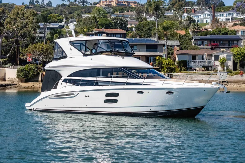 Slide: The Image of 2016 Meridian 441 Sedan yacht cruising near waterfront homes. - 2