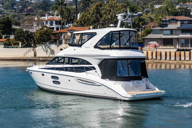 Slide: The Image of 2016 Meridian 441 Sedan yacht cruising near waterfront homes. - 6