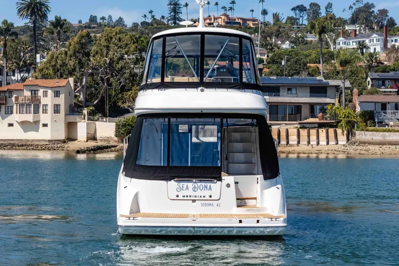 Slide: The Image of 2016 Meridian 441 Sedan yacht on water, coastal homes in background. - 7