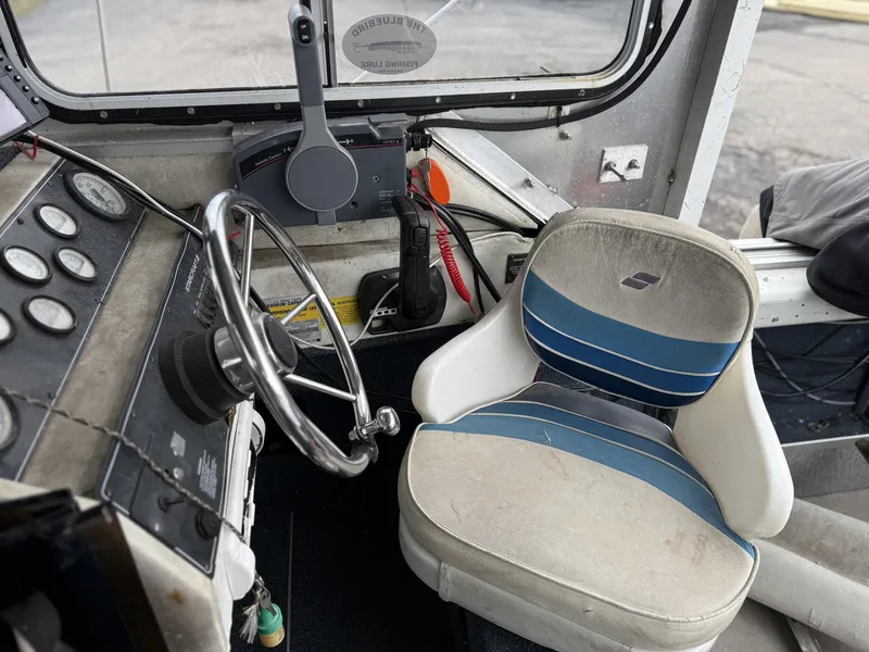 Slide: The Image of Interior of a 1993 Starcraft Islander 191 boat with steering wheel and seat. - 5