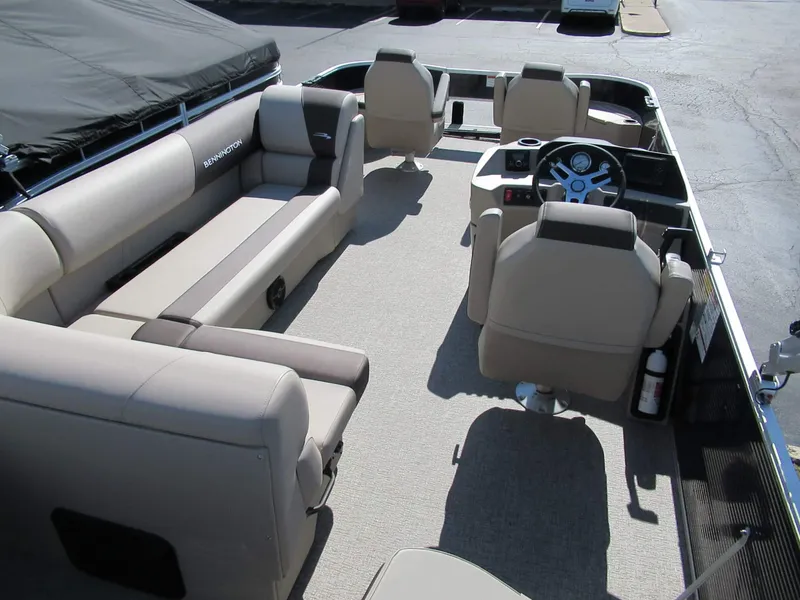 Slide: The Image of Interior view of a Bennington 22 SF pontoon boat with beige seating and a helm station. - 6