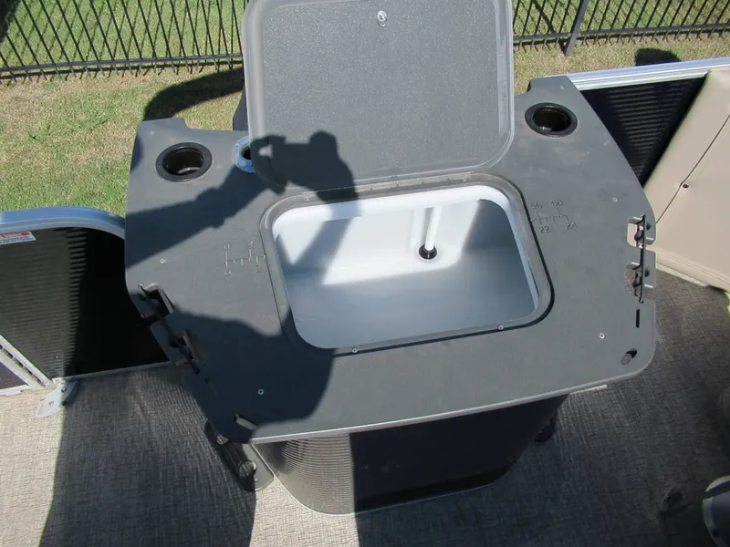 Slide: The Image of An open storage compartment with a lid on a boat, surrounded by cup holders. - 5