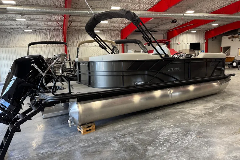 Slide: The Image of 2026 Sylvan Mirage X X5 pontoon boat in a showroom with Mercury outboard motor. - 3