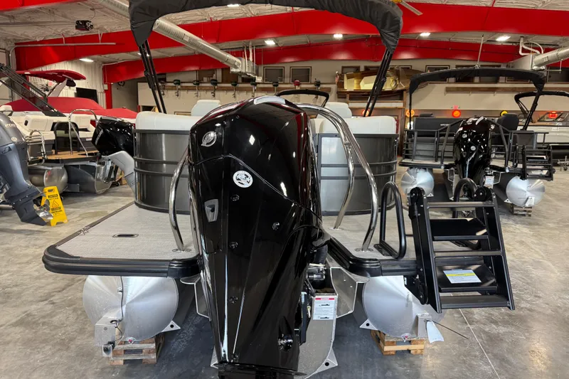 Slide: The Image of 2026 Sylvan Mirage X X5 pontoon boat in showroom, featuring sleek black motor and modern design. - 4