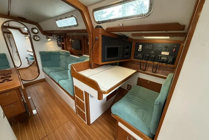 Slide: The Image of Interior of a 1996 J Boats J/160 sailboat with wood paneling and teal seating. - 10