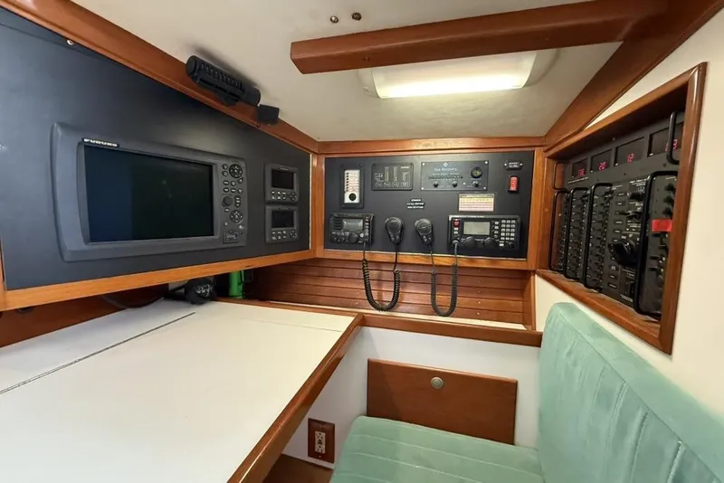 Slide: The Image of Navigation station of a 1996 J Boats J/160 yacht with control panels and seating. - 12
