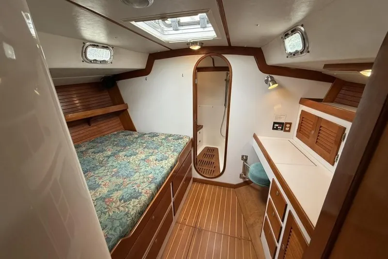 Slide: The Image of Interior of 1996 J Boats J/160 yacht, featuring a cozy cabin with bed and wooden accents. - 14