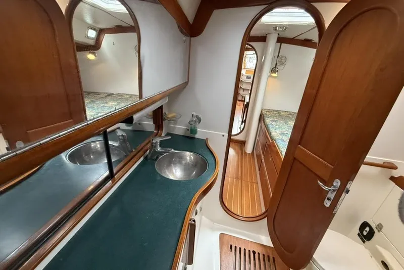 Slide: The Image of Interior of 1996 J Boats J/160 yacht featuring wooden cabinetry and dual sinks. - 20