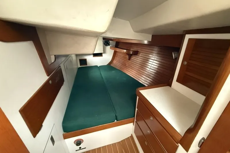 Slide: The Image of Interior cabin of 1996 J Boats J/160 sailboat with green cushions and wooden cabinetry. - 22