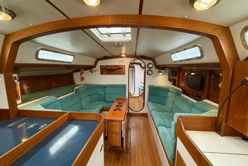Slide: The Image of Luxurious 1996 J Boats J/160 yacht interior with teal seating and wooden accents. - 5
