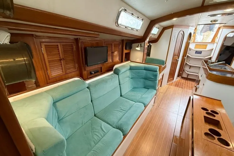 Slide: The Image of Interior of 1996 J Boats J/160 yacht with teal seating and wooden finishes. - 7