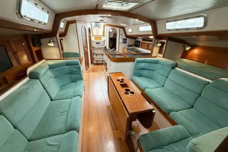 Slide: The Image of Luxurious interior of a 1996 J Boats J/160 yacht with teal seating and wooden accents. - 9