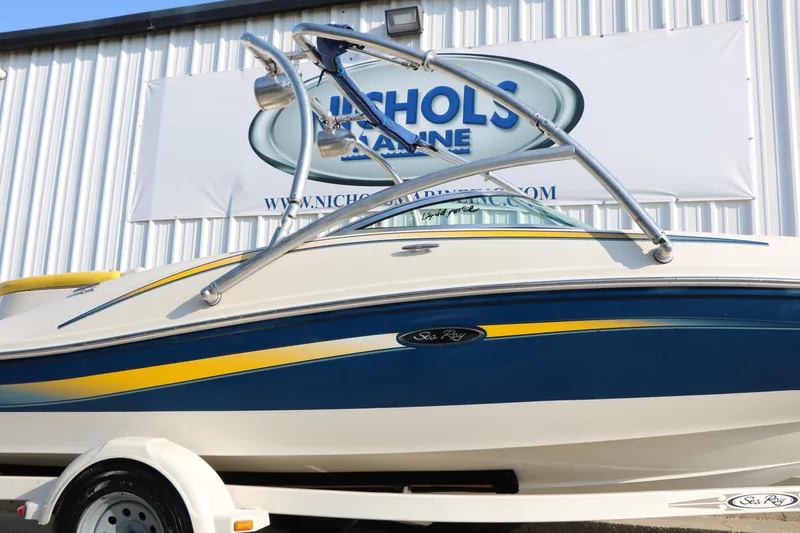 Slide: The Image of 2006 Sea Ray 185 Sport boat with blue and yellow accents, displayed at Nichols Marine. - 25