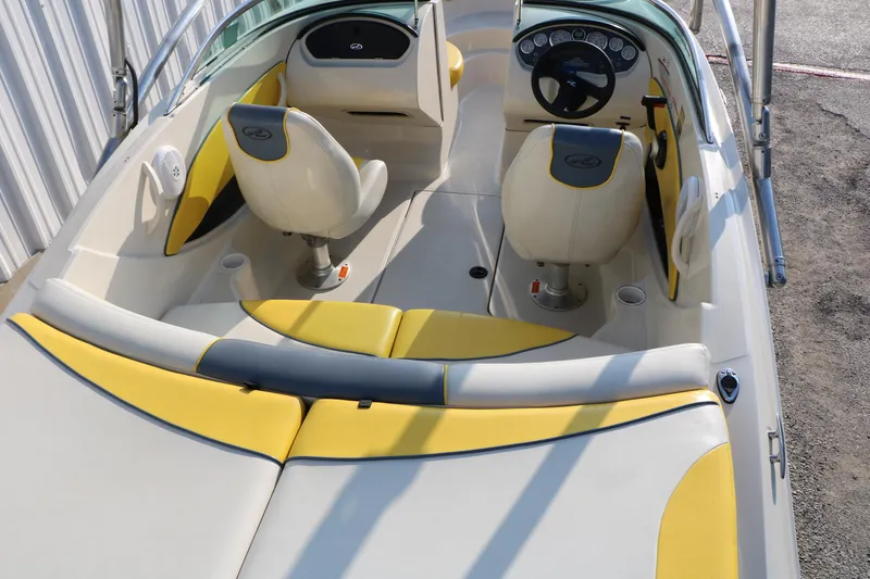 Slide: The Image of 2006 Sea Ray 185 Sport boat interior with yellow and white seating, steering wheel, and dashboard. - 35
