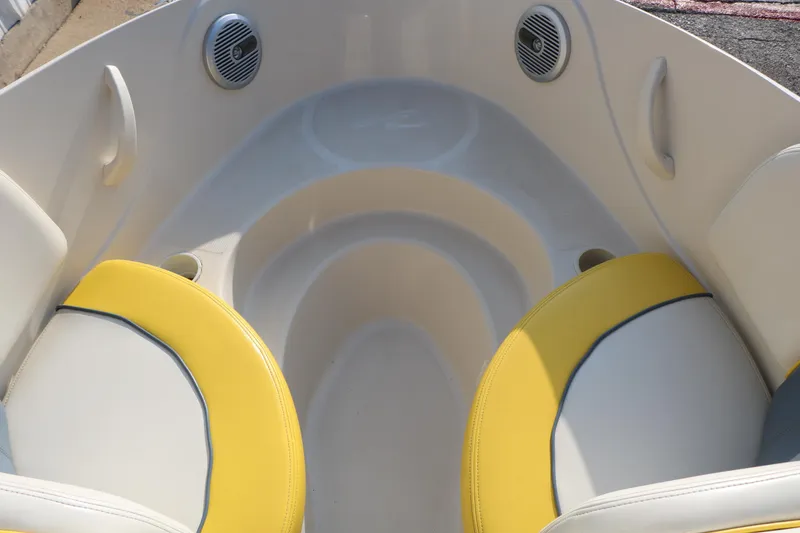 Slide: The Image of 2006 Sea Ray 185 Sport boat interior with yellow and white seating and built-in speakers. - 36