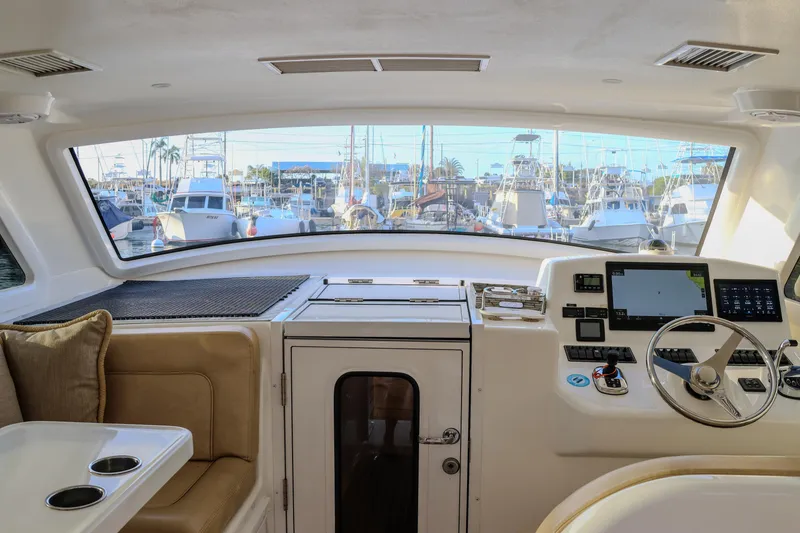 Slide: The Image of Interior view of 2017 Viking 37 Billfish yacht helm with marina backdrop. - 6