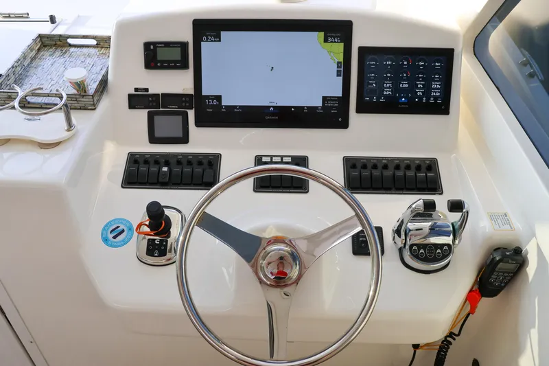 Slide: The Image of Control panel of a 2017 Viking 37 Billfish boat with navigation screens and steering wheel. - 7