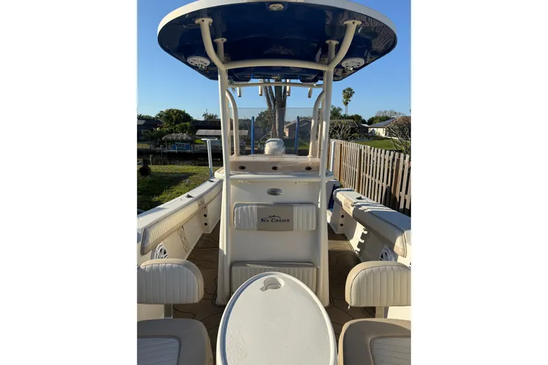 Slide: The Image of 2019 Sea Chaser 24 HFC boat interior with seating and console, parked outdoors. - 11