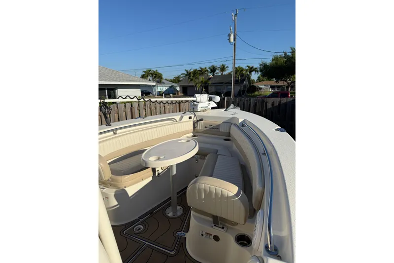 Slide: The Image of 2019 Sea Chaser 24 HFC boat with beige seating and round table in a residential setting. - 12