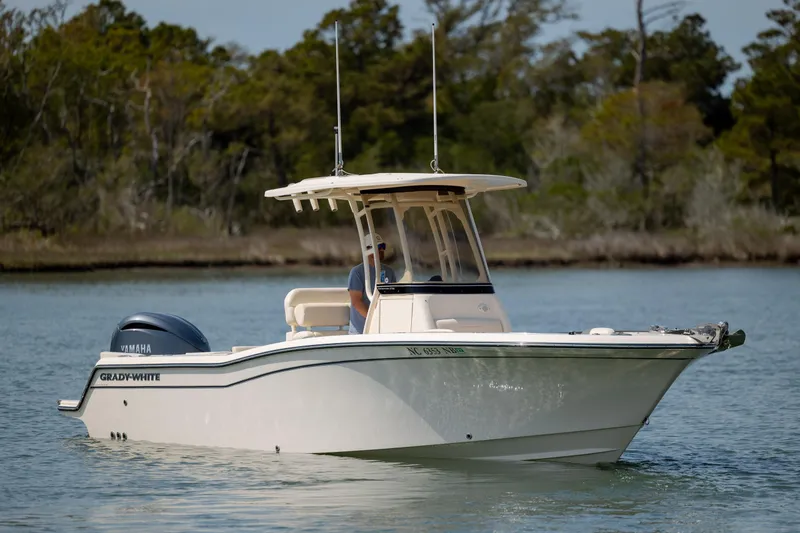 The Image of 2024 Grady-White Fisherman 236 boat cruising on a serene lake with lush greenery. - 0