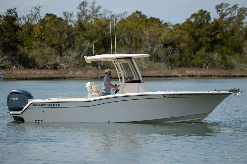 Slide: The Image of 2024 Grady-White Fisherman 236 boat on calm water, featuring sleek design and Yamaha engine. - 2