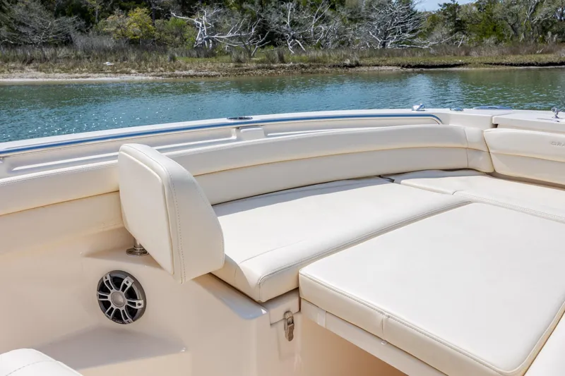 Slide: The Image of 2024 Grady-White Fisherman 236 boat interior with cushioned seating by the water. - 20